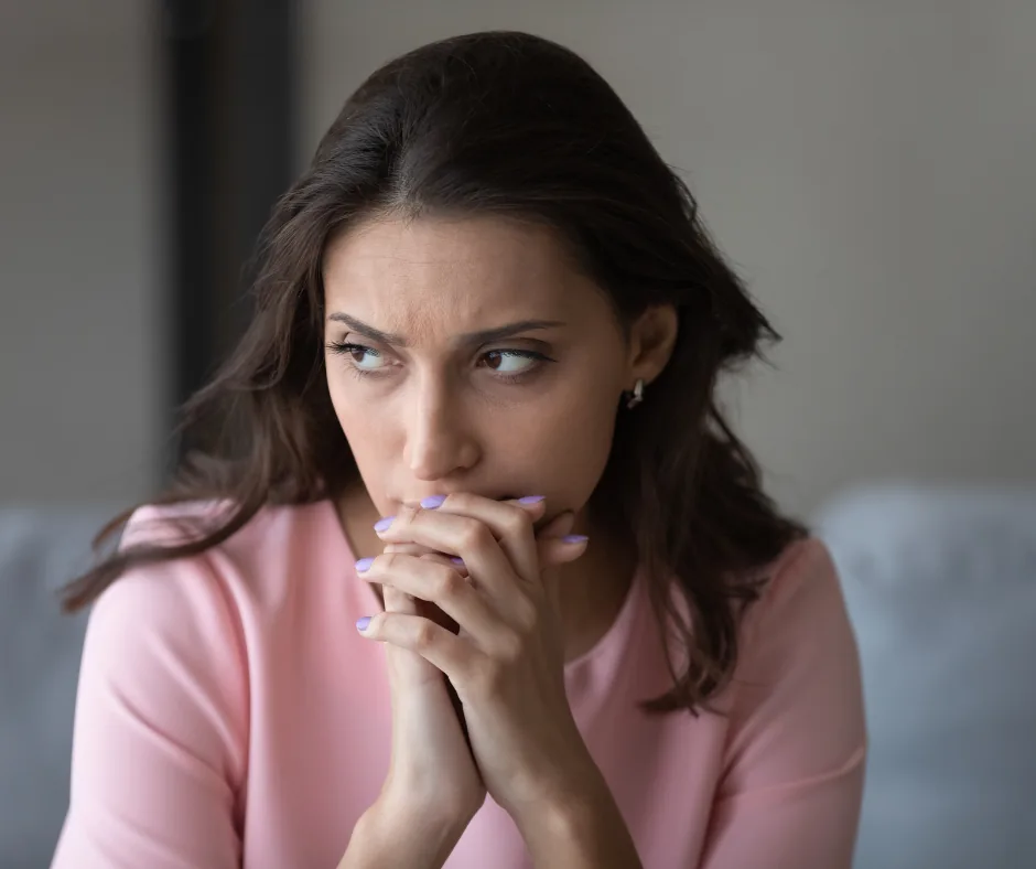 Woman with a worried expression, hands clasped, reflecting concern about mold issues in HVAC systems.
