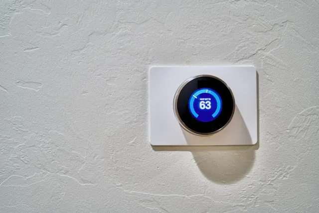 Picture of a thermostat set to 63 degrees.