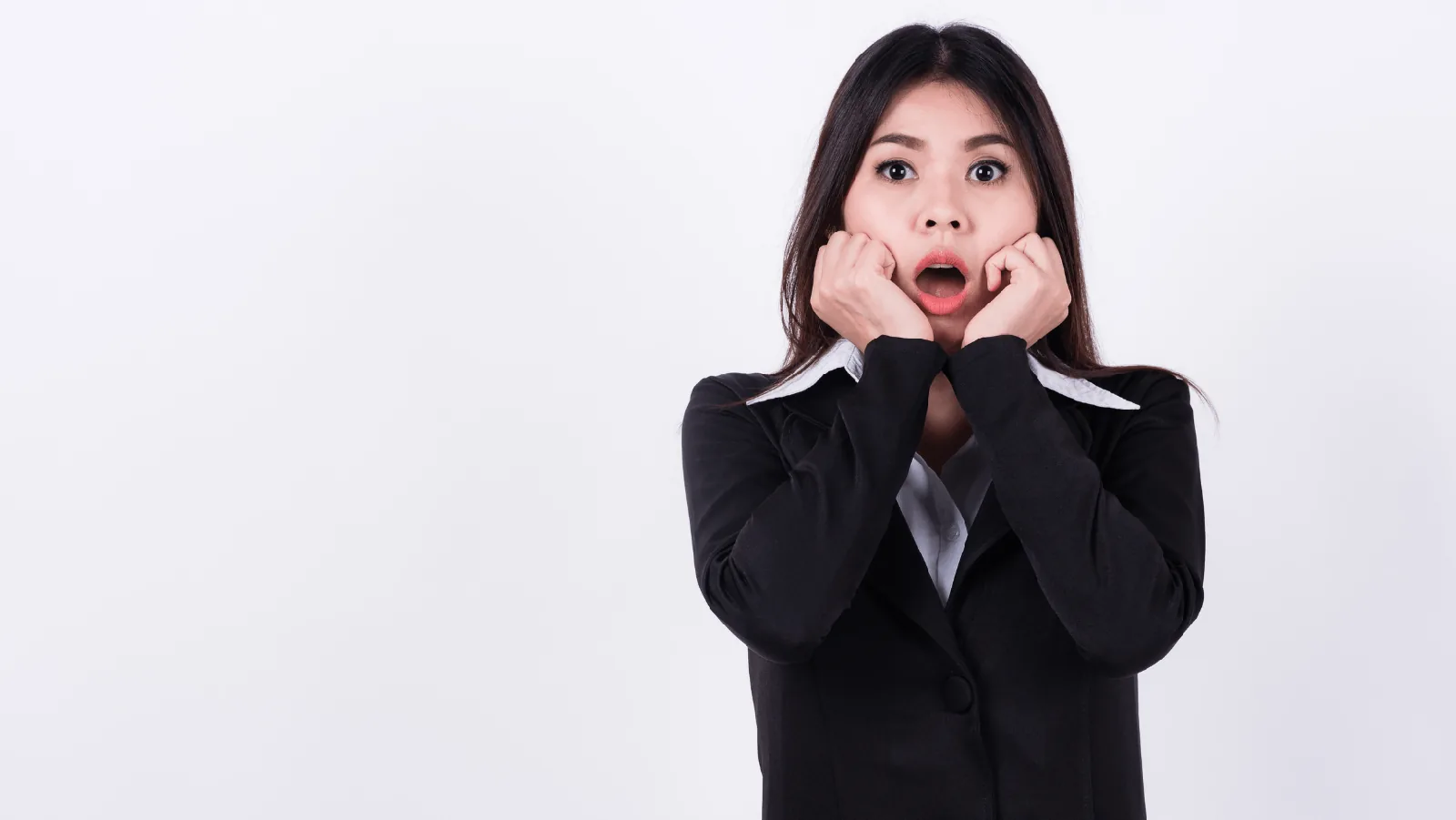 Woman in business attire with a shocked expression, illustrating common air conditioning issues and homeowner concerns.