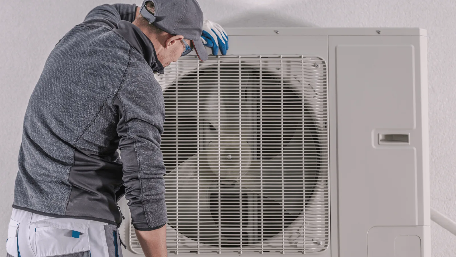 Technician servicing a ductless mini-split heat pump, emphasizing HVAC maintenance and installation services.