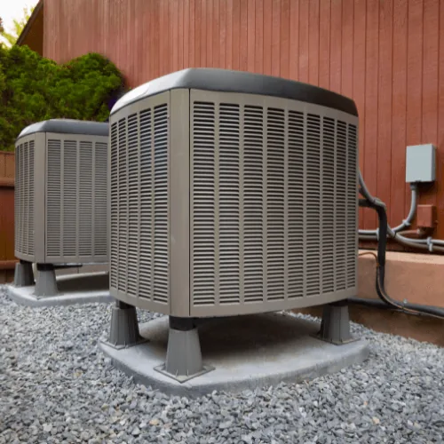 Heat pumps installed outside a home, highlighting energy efficiency and HVAC systems.
