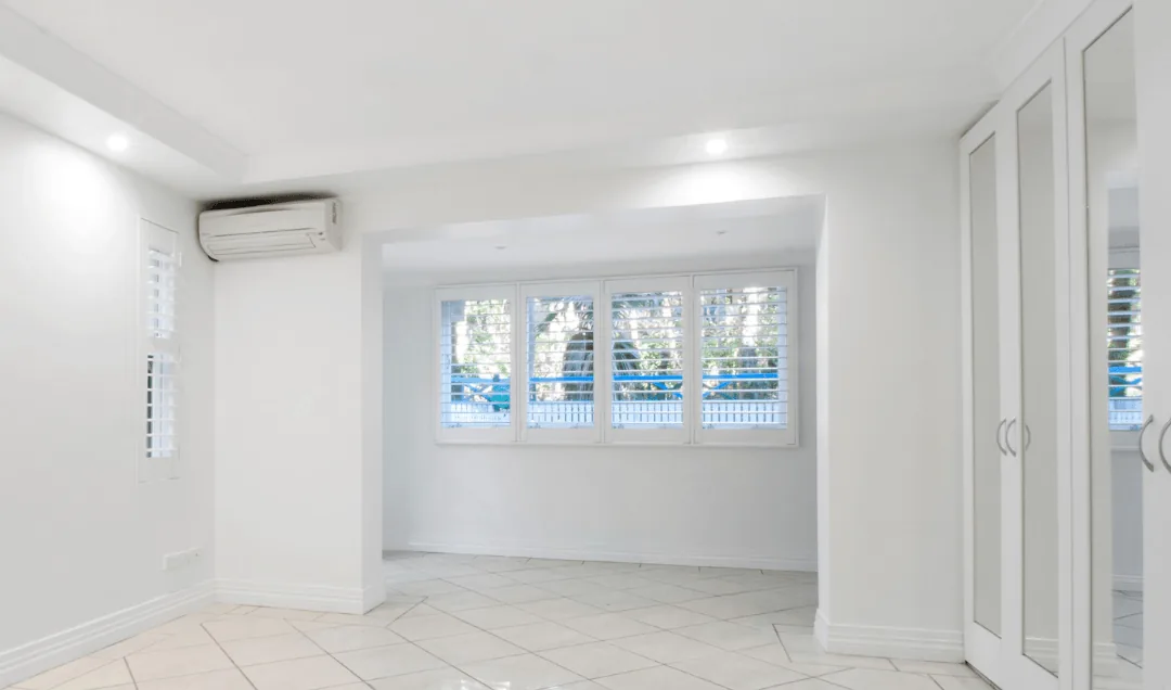 Ductless mini-split air conditioning unit mounted on a white wall in a bright, modern room