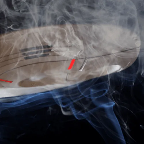 Duct-mounted smoke detector emitting smoke, illustrating its role in HVAC systems for smoke detection and prevention of smoke circulation.