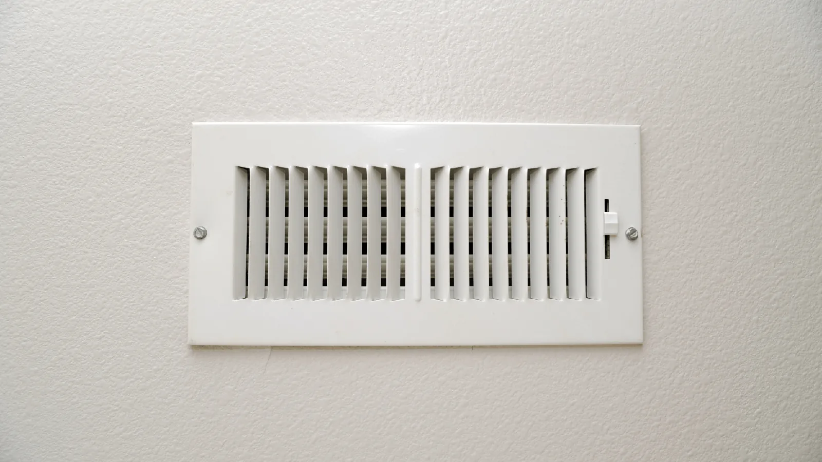 Air vent installed on a wall, emphasizing HVAC system functionality and airflow management, relevant to heating and cooling advice.