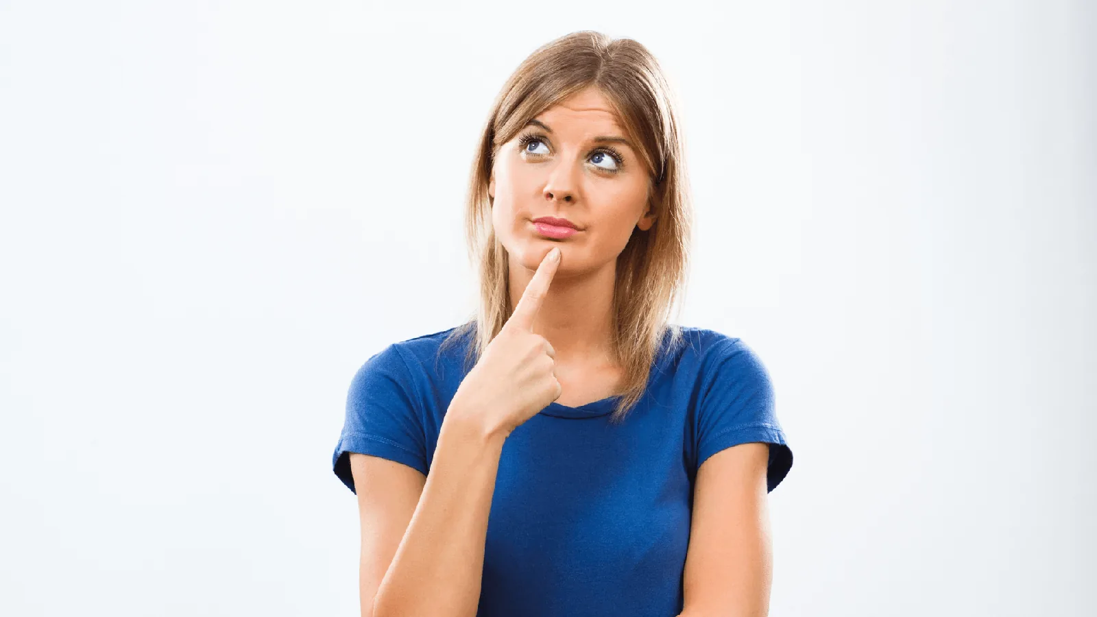 Woman in blue shirt pondering, finger on chin, contemplating ductless heat pump benefits and installation decisions.