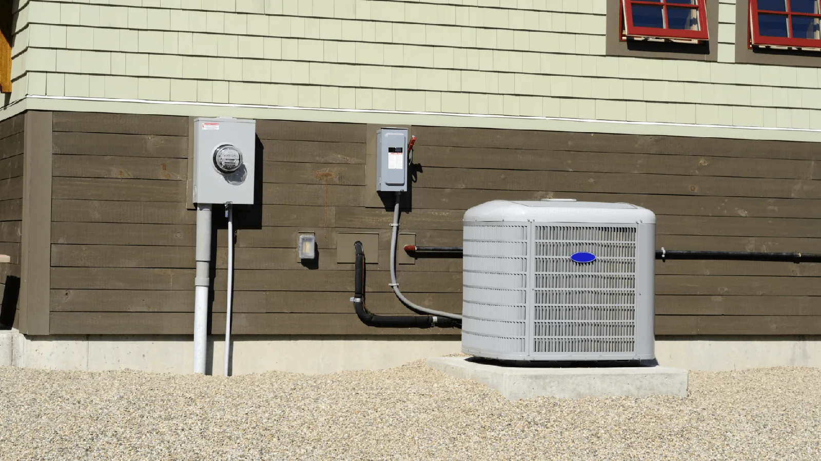 HVAC outdoor unit installed beside a home, with electrical meter and conduit, illustrating AC installation and maintenance services.