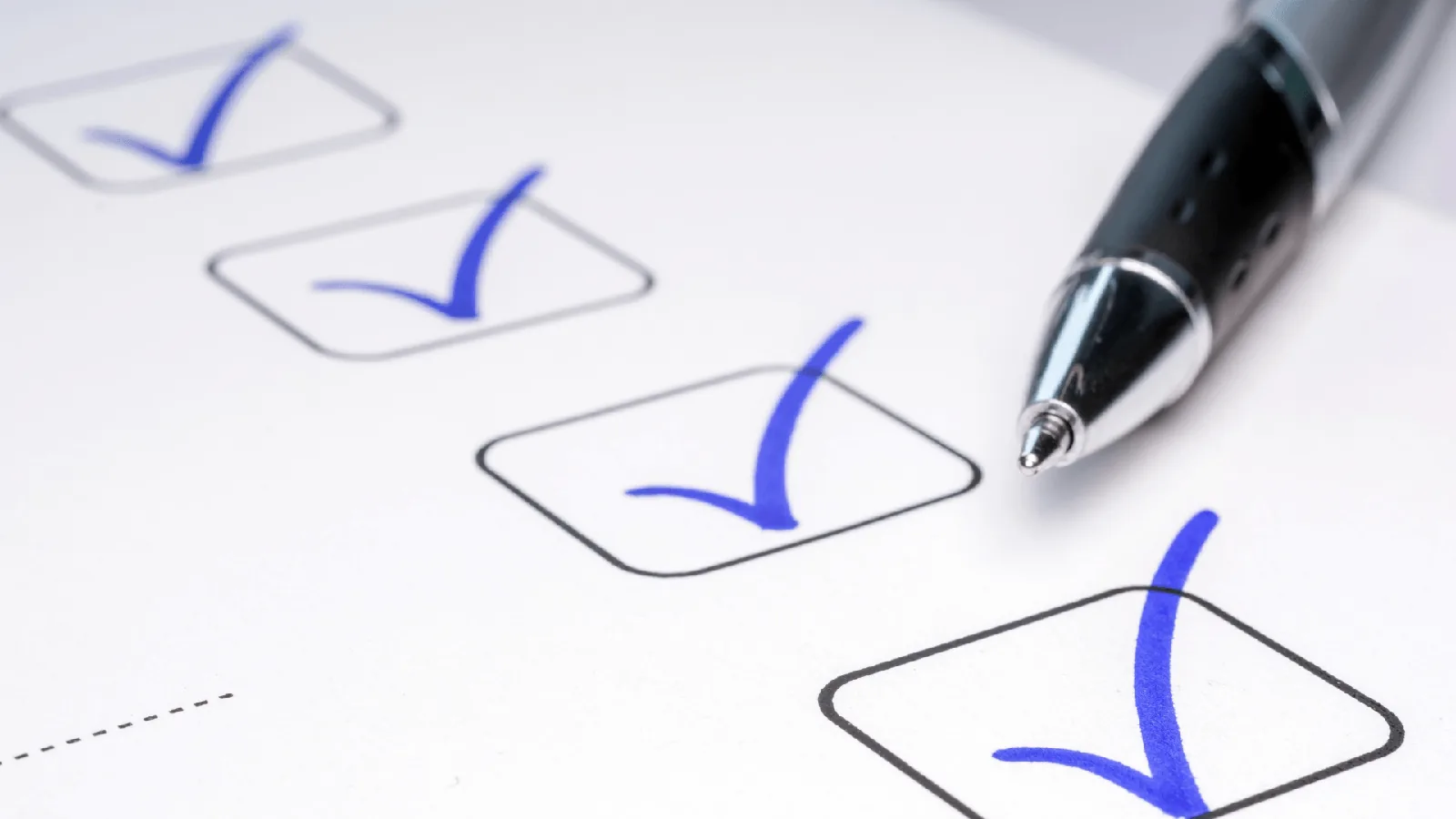 Checklist with blue check marks and a pen, symbolizing DIY maintenance tasks for HVAC systems.