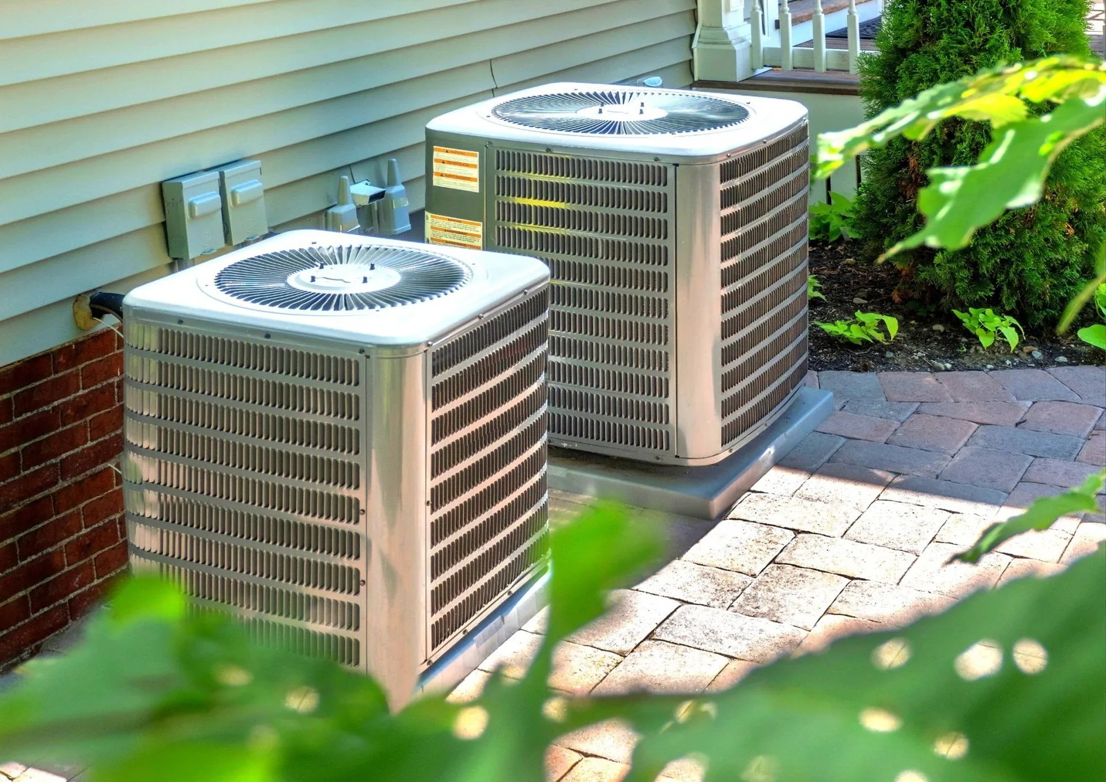 HVAC units installed outside a home, showcasing heat pumps and energy-efficient cooling systems, relevant to residential