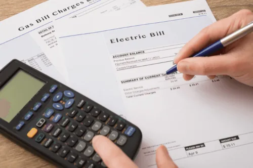 Person reviewing electric bill and gas bill statements