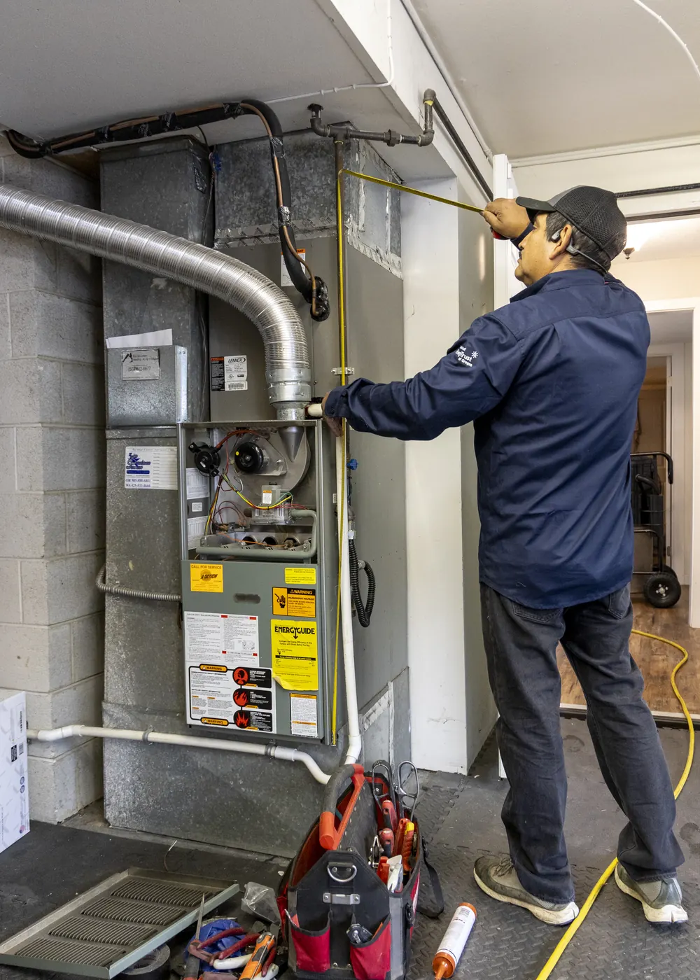 A Best Owner Direct technician servicing a gas furnace