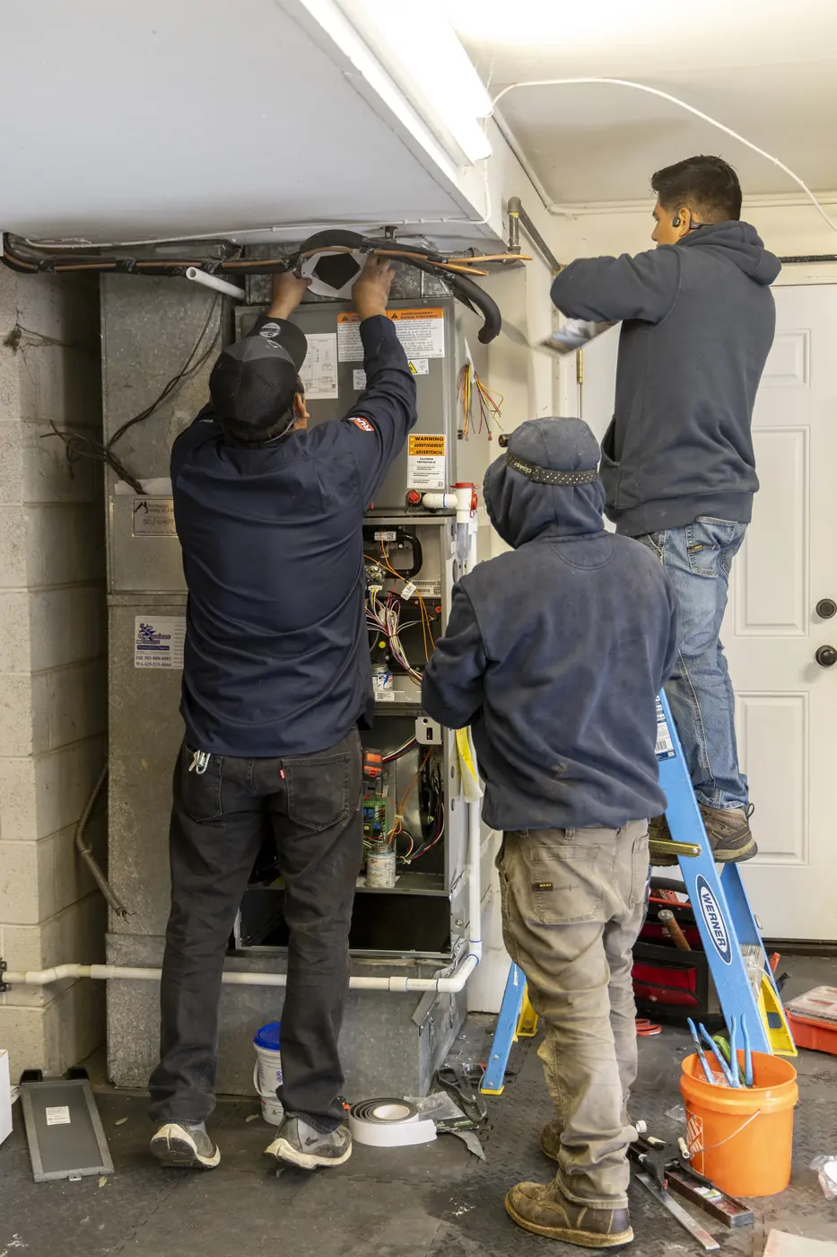 Two technicians installing a new air handler