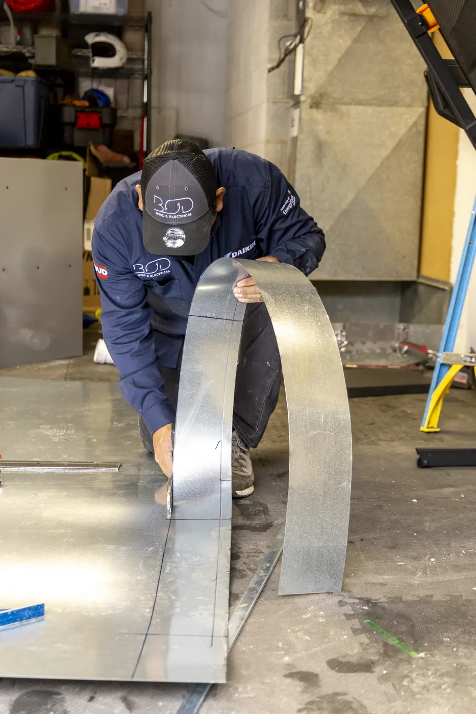 Technician bending a sheet-metal duct section