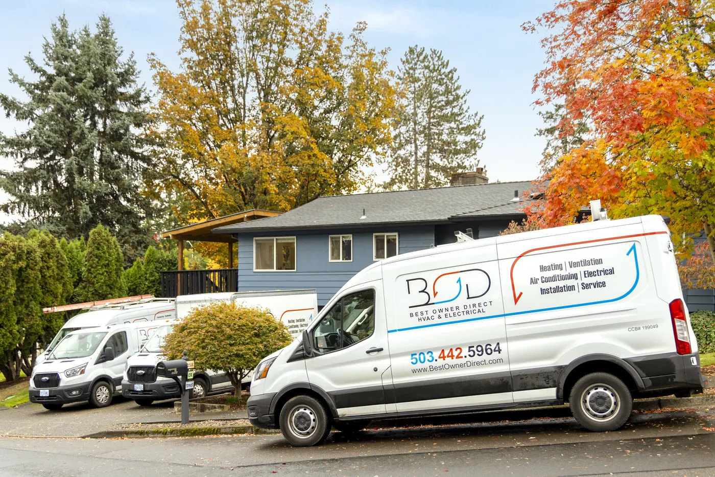 Best Owner Direct HVAC & Electrical service vans in front of a home in autumn