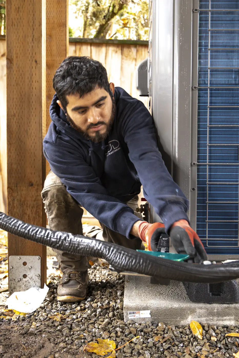 Technician connecting a ductless mini-split line set at the outdoor unit