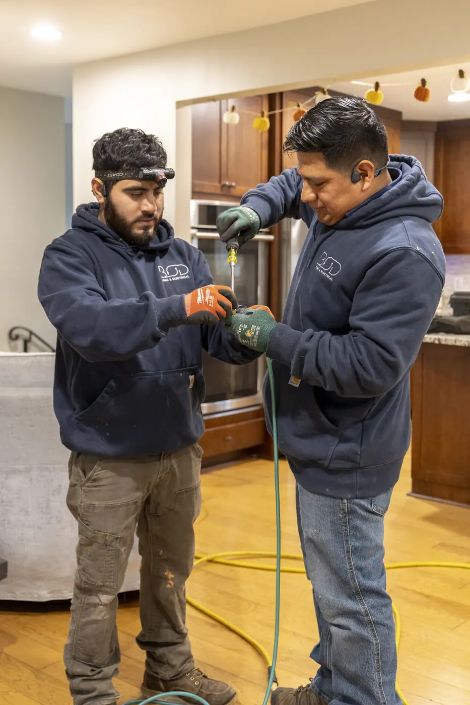 Two technicians working together on a kitchen service call