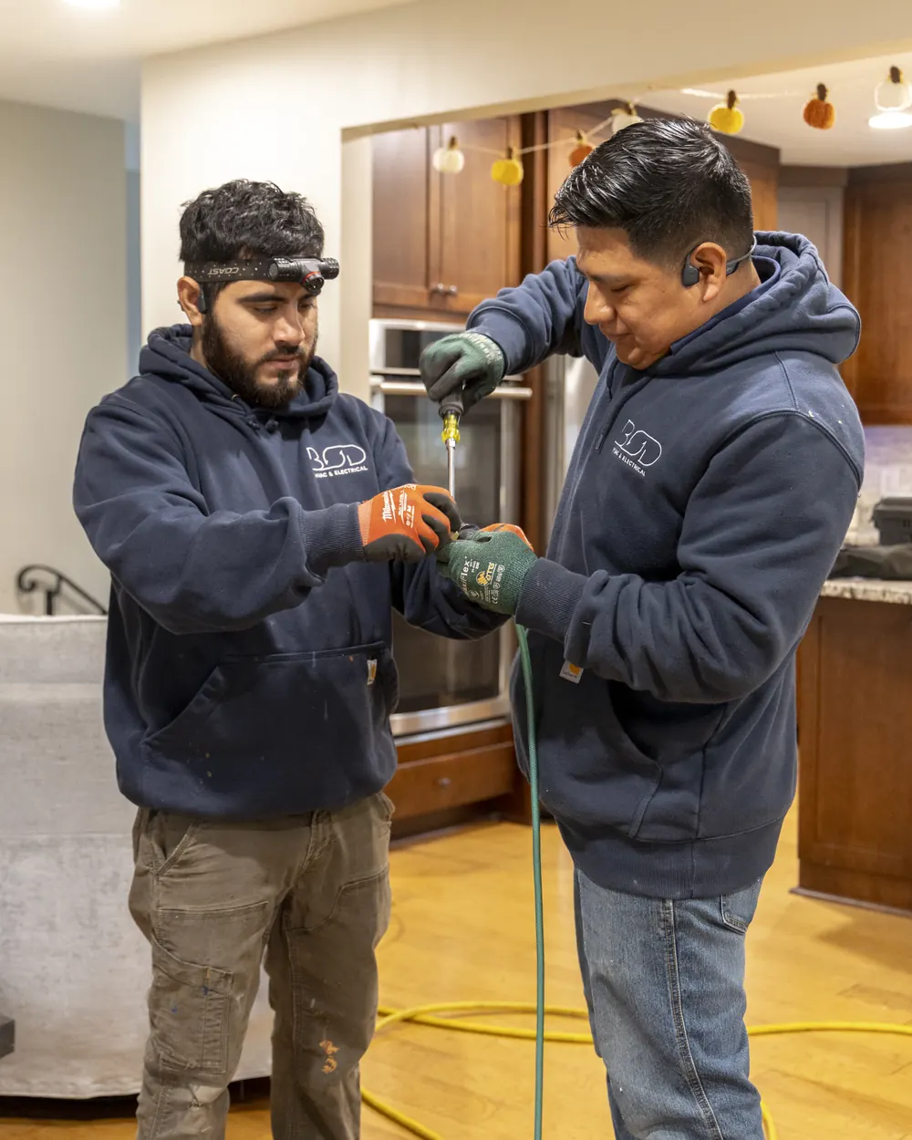 Two Best Owner Direct technicians working together on a home service call